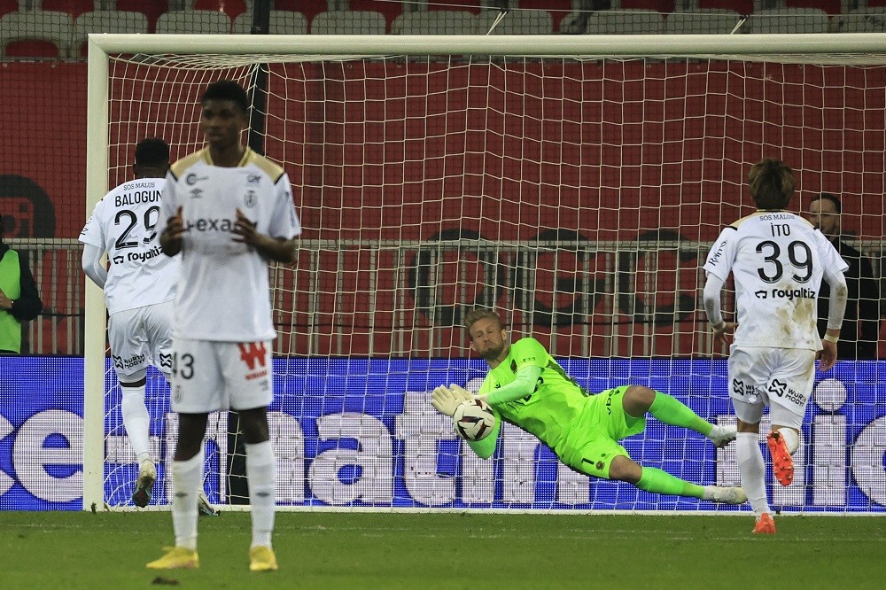 Nice's Danish goalkeeper Kasper Schmeichel (C) stops a penalty shot by Reims' English forward Folarin Balogun (L) during the French L1 football match between OGC Nice and Stade de Reims at the Allianz Riviera Stadium in Nice, south-eastern France, on February 18, 2023. (Photo by VALERY HACHE/AFP via Getty Images)
