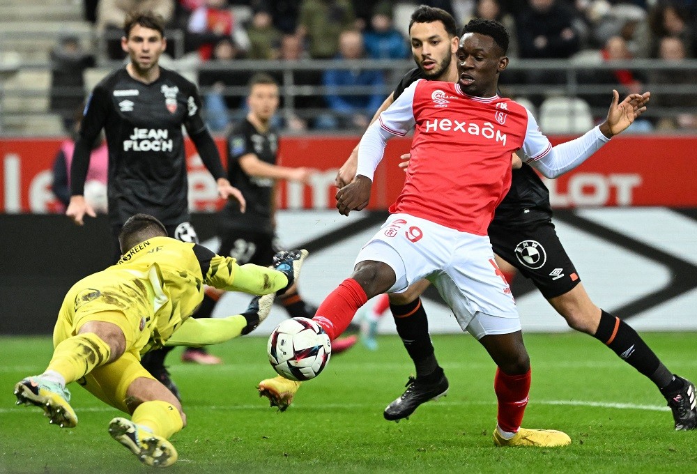 Reims' English forward Folarin Balogun (R) fights for the ball with Lorient goalkeeper Vito Mannone (L) during the French L1 football match between Stade de Reims and FC Lorient at Stade Auguste-Delaune in Reims, northern France on February 1, 2023. (Photo by DENIS CHARLET/AFP via Getty Images)