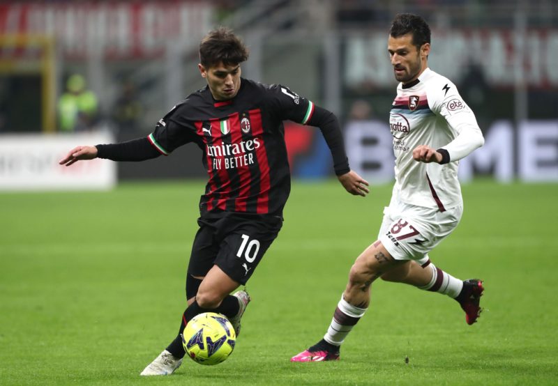 Brahim Diaz, wearing the red and black jersey of AC Milan, competes for the ball with Antonio Candreva of US Salernitana during a Serie A match at Stadio Giuseppe Meazza. The image was taken on March 13, 2023, in Milan, Italy, and credit goes to Marco Luzzani/Getty Images.