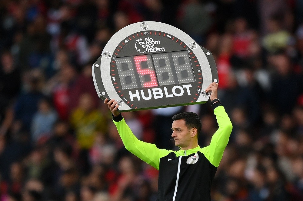 LONDON, ENGLAND: Fourth official Andy Madley lifts the 'No Room For Racism' substitution LED board during the Premier League match between Arsenal FC and Liverpool FC at Emirates Stadium on October 09, 2022. (Photo by Shaun Botterill/Getty Images)