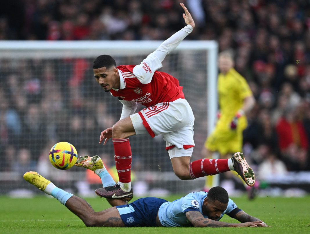 Arsenal's French defender William Saliba (top) fouls Brentford's English striker Ivan Toney during the English Premier League football match between Arsenal and Brentford at the Emirates Stadium in London on February 11, 2023.