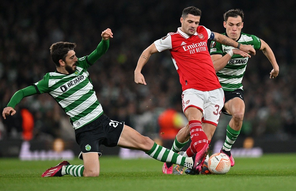 Arsenal's Swiss midfielder Granit Xhaka (C) vies with Sporting Lisbon's Portuguese striker Paulinho (L) and Sporting Lisbon's Uruguayan midfielder Ugarte during the UEFA Europa League round of 16, second-leg football match between Arsenal and Sporting Lisbon at the Emirates Stadium in London on March 16, 2023. (Photo by GLYN KIRK/AFP via Getty Images)