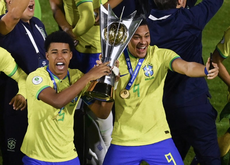 Brazil's Andrey Santos (L) and Vitor Roque hold the trophy after winning the South American U-20 football championship after defeating Uruguay 2-0 in their final round match, at El Campin stadium in Bogota, on February 12, 2023. (Photo by Juan BARRETO / AFP) (Photo by JUAN BARRETO/AFP via Getty Images)
