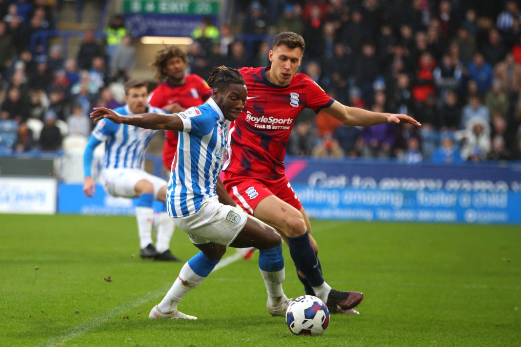 HUDDERSFIELD, ENGLAND - FEBRUARY 18: Joseph Hungbo of Huddersfield Town is challenged by Krystian Bielik of Birmingham City during the Sky Bet Championship between Huddersfield Town and Birmingham City at John Smith's Stadium on February 18, 2023 in Huddersfield, England. (Photo by Ashley Allen/Getty Images)
