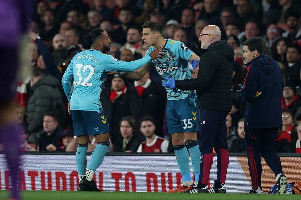 Southampton's doctor Steve Baynes (2R) holds onto Jan Bednarek (C) as Theo Walcott (L) attempts to convince him not to come back on, having been hurt during the English Premier League football match between Arsenal and Southampton at the Emirates Stadium in London on April 21, 2023. (Photo by ADRIAN DENNIS/AFP via Getty Images)