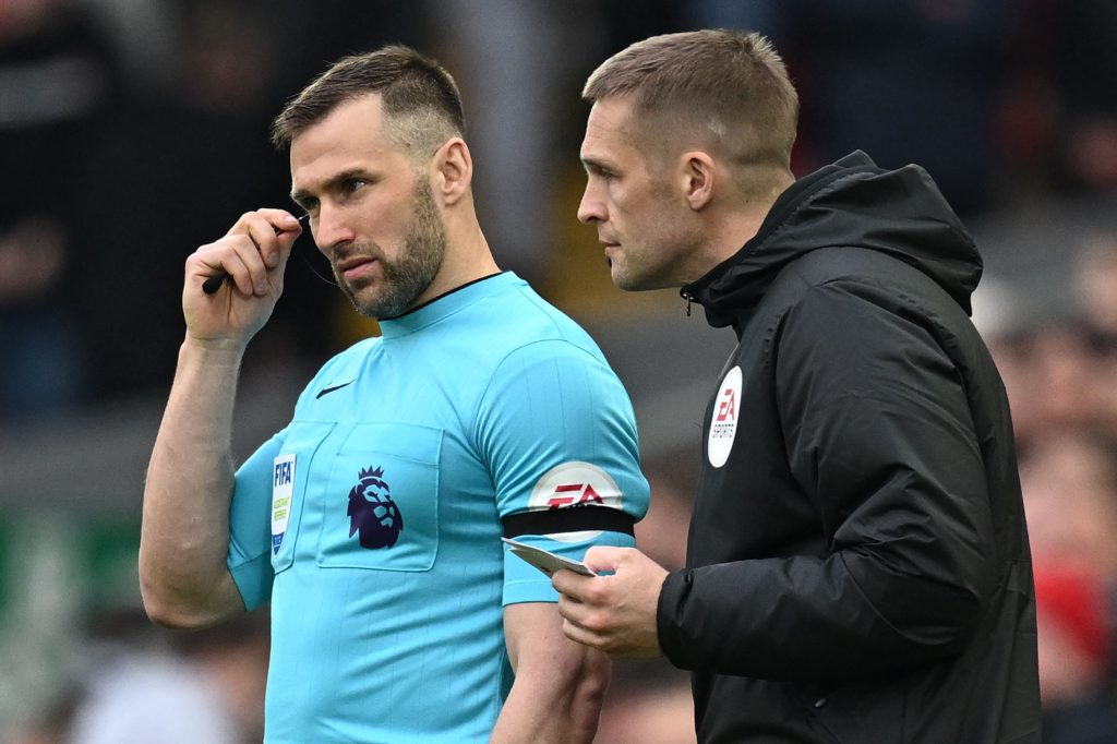 Fourth Official Craig Pawson talks to assistant referee and linesman Assistant Referee Constantine Hatzidakis during the English Premier League football match between Liverpool and Arsenal at Anfield in Liverpool, north west England on April 9, 2023.(Photo by PAUL ELLIS/AFP via Getty Images)