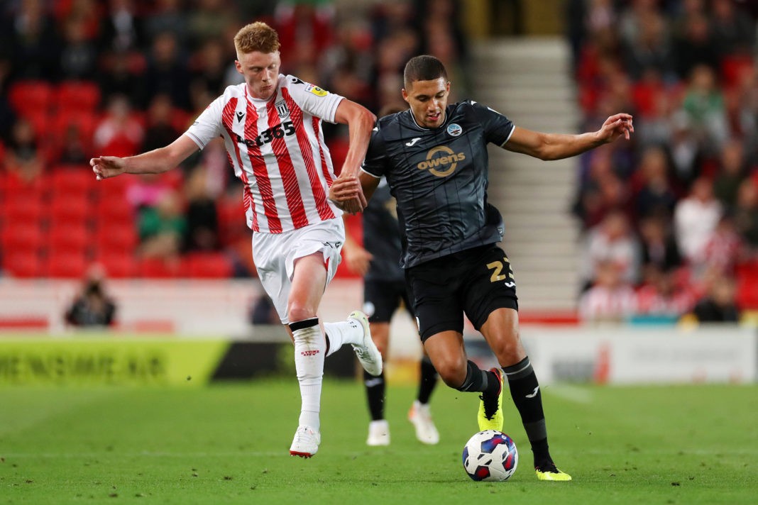 STOKE ON TRENT, ENGLAND - AUGUST 31: Nathan Wood of Swansea City is tackled by Sam Clucas of Stoke City during the Sky Bet Championship between Stoke City and Swansea City at Bet365 Stadium on August 31, 2022 in Stoke on Trent, England. (Photo by Lewis Storey/Getty Images)