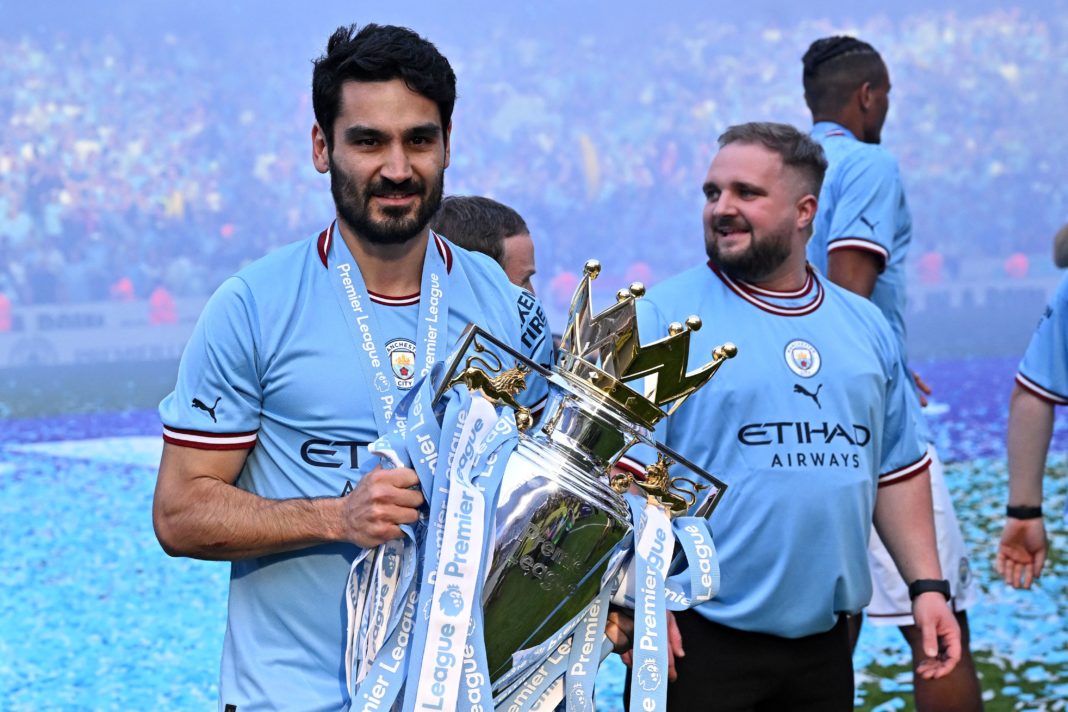 Manchester City's German midfielder Ilkay Gundogan poses with the Premier League trophy on the pitch after the presentation ceremony following the English Premier League football match between Manchester City and Chelsea at the Etihad Stadium in Manchester, north-west England, on May 21, 2023. (Photo by OLI SCARFF/AFP via Getty Images)