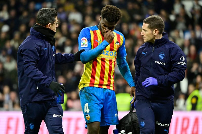 Valencia's US midfielder Yunus Musah (C) receives medical attention as he leaves the pitch during the Spanish league football match between Real Madrid CF and Valencia CF at the Santiago Bernabeu stadium in Madrid on February 2, 2023. (Photo by JAVIER SORIANO / AFP) (Photo by JAVIER SORIANO/AFP via Getty Images)