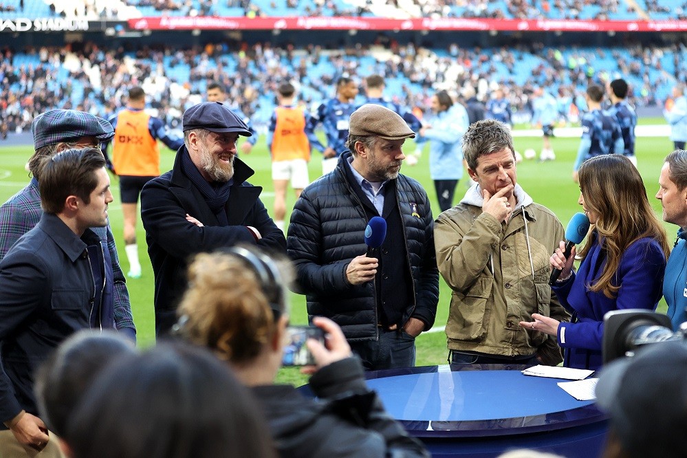 MANCHESTER, ENGLAND: (L-R) Actors Phil Dunster, James Lance, Brendan Hunt, and Jason Sudeikis from the television show Ted Lasso and Noel Gallagher are interviewed prior to the Premier League match between Manchester City and Arsenal FC at Etihad Stadium on April 26, 2023. (Photo by Catherine Ivill/Getty Images)