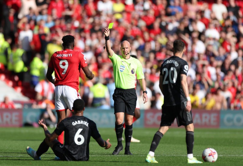 NOTTINGHAM, ENGLAND - MAY 20: Referee Anthony Taylor shows a yellow card to Taiwo Awoniyi of Nottingham Forest during the Premier League match between Nottingham Forest and Arsenal FC at City Ground on May 20, 2023 in Nottingham, England. (Photo by Catherine Ivill/Getty Images)