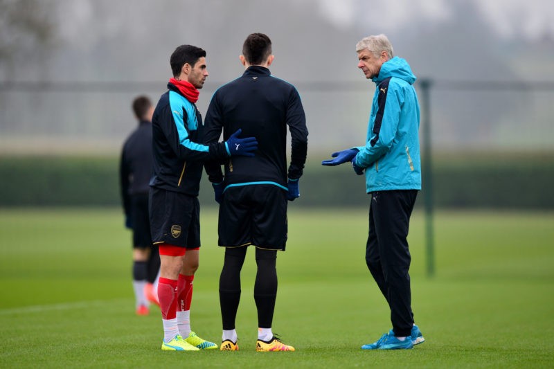 ST ALBANS, ENGLAND - MARCH 15: Arsene Wenger, Manager of Arsenal speaks with Mikel Arteta and Gabriel Paulista of Arsenal during a training session ahead of the UEFA Champions League round of 16 second leg match between Barcelona and Arsenal at London Colney on March 15, 2016 in St Albans, England. (Photo by Dan Mullan/Getty Images)