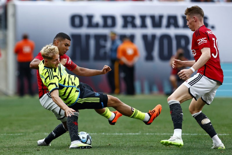 EAST RUTHERFORD, NEW JERSEY - JULY 22: Emile Smith Rowe (C) #10 of Arsenal is pulled down by Casemiro #18 of Manchester United during the second half of a pre-season friendly match at MetLife Stadium on July 22, 2023 in East Rutherford, New Jersey. Manchester United defeated Arsenal 2-0. (Photo by Rich Schultz/Getty Images)