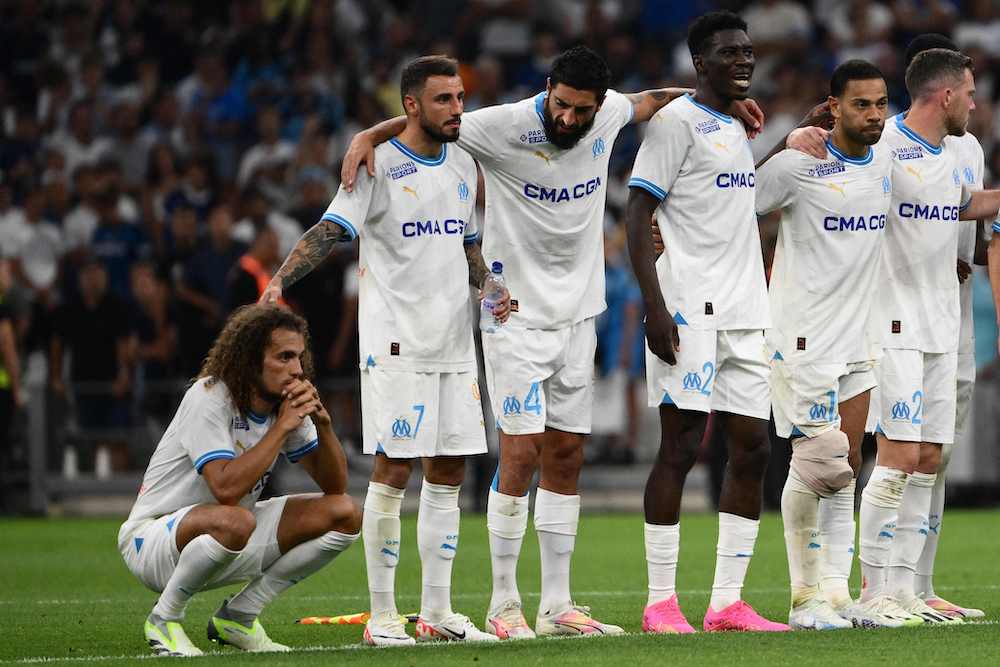 Marseille midfielder Matteo Guendouzi (L) reacts after missing his penalty during the penalty shootout of the UEFA Champions League second leg of the third qualifying round football match between Olympique Marseille (OM) and Panathinaikos at the Velodrome stadium in Marseille, on August 15, 2023. (Photo by CHRISTOPHE SIMON/AFP via Getty Images)
