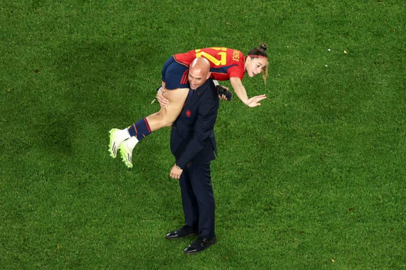 This picture taken on August 20, 2023 shows President of the Royal Spanish Football Federation Luis Rubiales carrying Spain's Athenea del Castillo Beivide on his shoulder as they celebrate winning the Australia and New Zealand 2023 Women's World Cup final football match between Spain and England at Stadium Australia in Sydney. (Photo by DAVID GRAY/AFP via Getty Images)