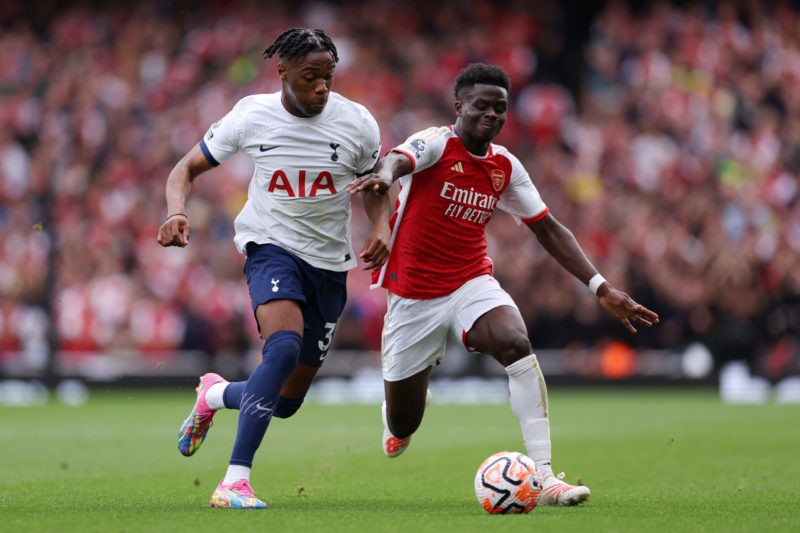 LONDON, ENGLAND - SEPTEMBER 24: Destiny Udogie of Tottenham Hotspur battles for possession with Bukayo Saka of Arsenal during the Premier League match between Arsenal FC and Tottenham Hotspur at Emirates Stadium on September 24, 2023 in London, England. (Photo by Alex Pantling/Getty Images)