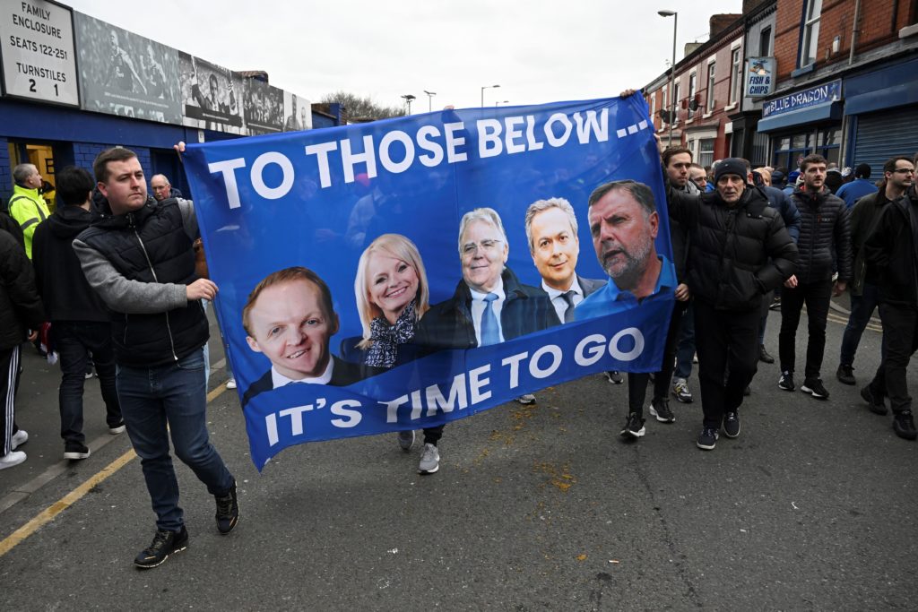 Everton fans protest hold a banner reading "It's time to go..." with portraits of club owner Farhad Moshiri (2ndR) and board members (from L) Grant Ingles, Denise Barrett-Baxendale, Bill Kenwright, and Graeme Sharp during a protest ahead of the English Premier League football match between Everton and Arsenal at Goodison Park in Liverpool, north-west England, on February 4, 2023. (Photo by PAUL ELLIS/AFP via Getty Images)