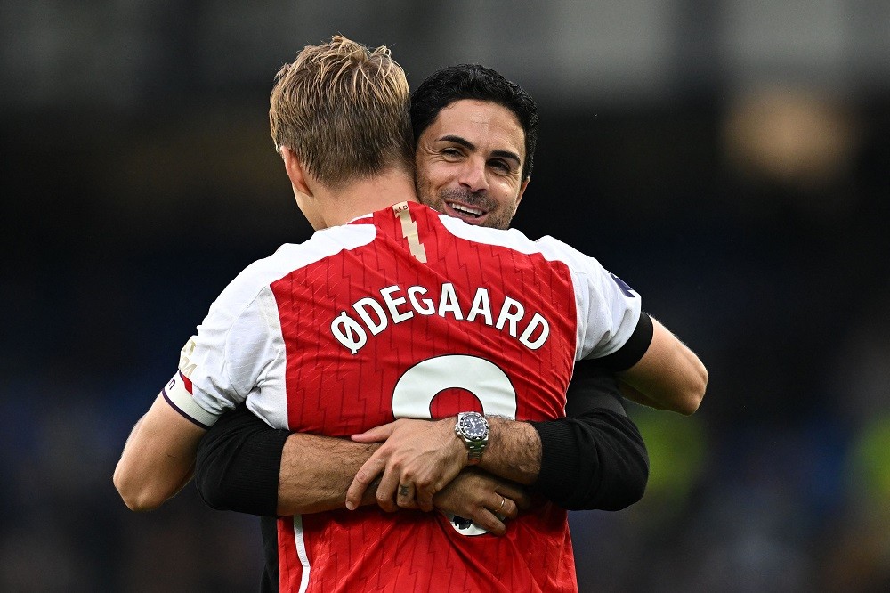 Arsenal's Norwegian midfielder Martin Odegaard is embraced by Arsenal's Spanish manager Mikel Arteta on the pitch after the English Premier League football match between Everton and Arsenal at Goodison Park in Liverpool, north west England on September 17, 2023. (Photo by PAUL ELLIS/AFP via Getty Images)