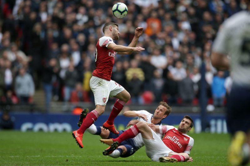 Arsenal's German defender Shkodran Mustafi heads clear as Tottenham Hotspur's English striker Harry Kane (C) and Arsenal's Greek defender Sokratis Papastathopoulos (R) hit the deck during the English Premier League football match between Tottenham Hotspur and Arsenal at Wembley Stadium in London, on March 2, 2019. (Photo by DANIEL LEAL/AFP via Getty Images)