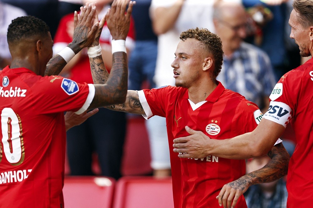 PSV's Dutch defender Patrick van Aanholt (L) and PSV's Dutch forward Noa Lang (C) celebrate after scoring the team's first goal during a Dutch Eredivisie premier league match between PSV Eindhoven and FC Utrecht at Phillips stadium in Eindhoven on August 12, 2023. (Photo by MAURICE VAN STEEN/ANP/AFP via Getty Images)