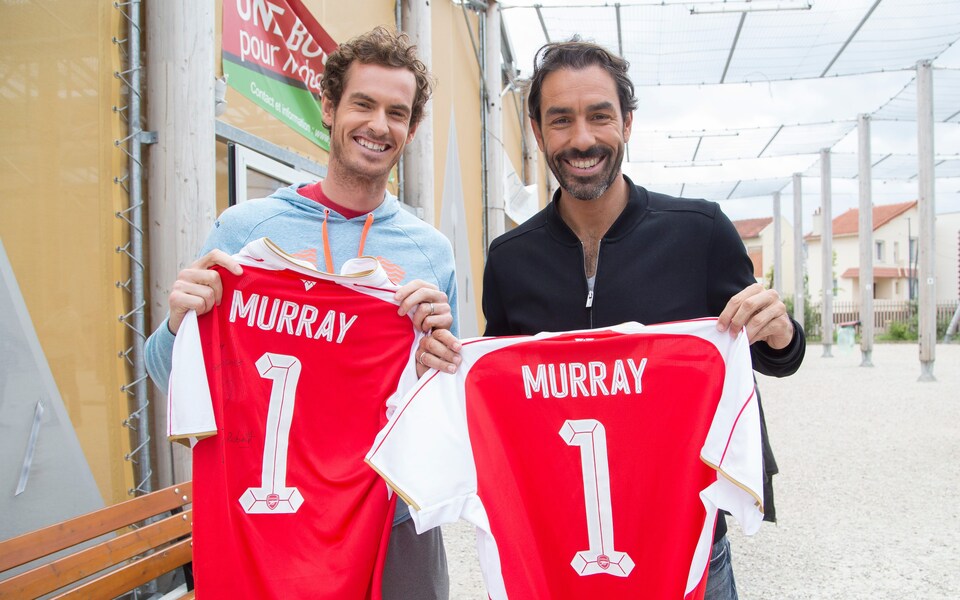 Andy Murray holding an Arsenal shirt with his name printed on it alongside Robert Pires in 2016 (Photo via The Telegraph)