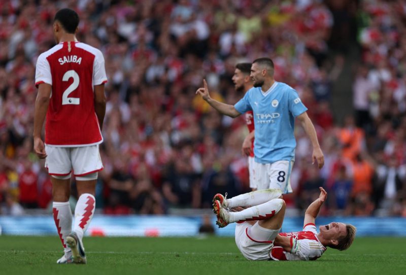 Arsenal's Norwegian midfielder #08 Martin Odegaard (R) reacts after being fouled by Manchester City's Croatian midfielder #08 Mateo Kovacic (2R) during the English Premier League football match between Arsenal and Manchester City at the Emirates Stadium in London on October 8, 2023. (Photo by ADRIAN DENNIS/AFP via Getty Images)