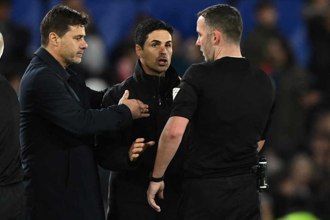 Arsenal's Spanish manager Mikel Arteta (C) talks himself into a yellow card after speaking to English referee Chris Kavanagh (R) as Chelsea's Argentinian head coach Mauricio Pochettino (L) stands by after the English Premier League football match between Chelsea and Arsenal at Stamford Bridge in London on October 21, 2023. The game finished 2-2. (Photo by JUSTIN TALLIS/AFP via Getty Images)