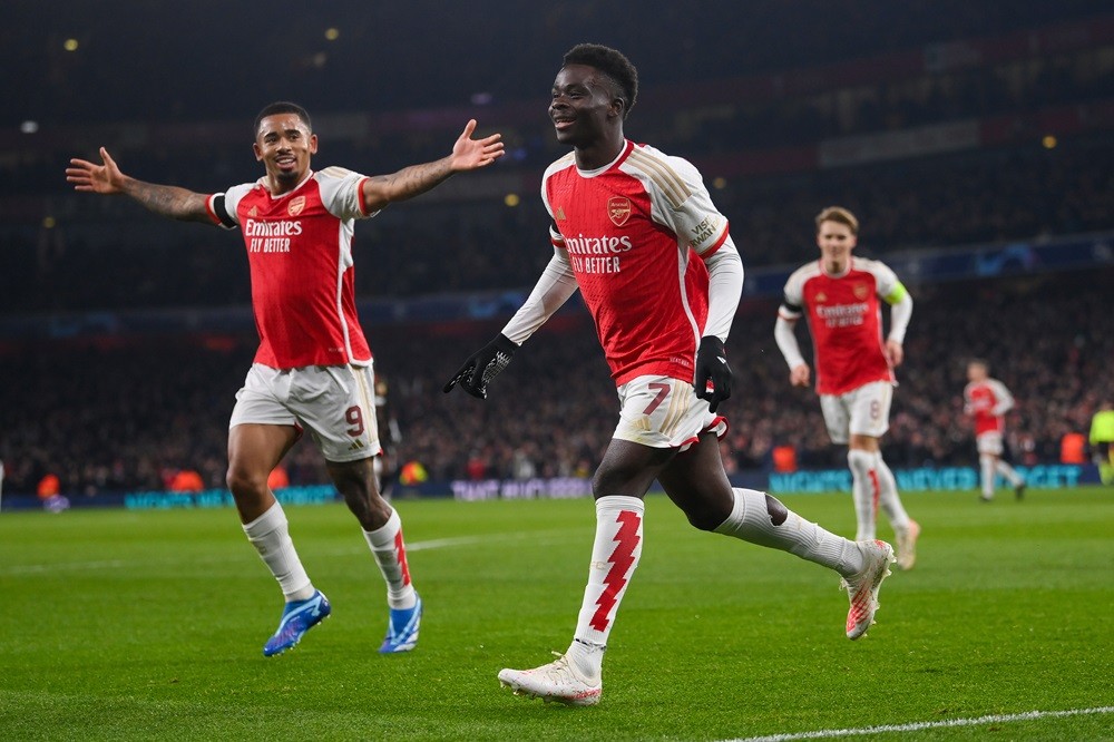 LONDON, ENGLAND: Bukayo Saka of Arsenal celebrates with Gabriel Jesus after scoring his team's third goal during the UEFA Champions League match between Arsenal FC and RC Lens at Emirates Stadium on November 29, 2023. (Photo by Mike Hewitt/Getty Images)