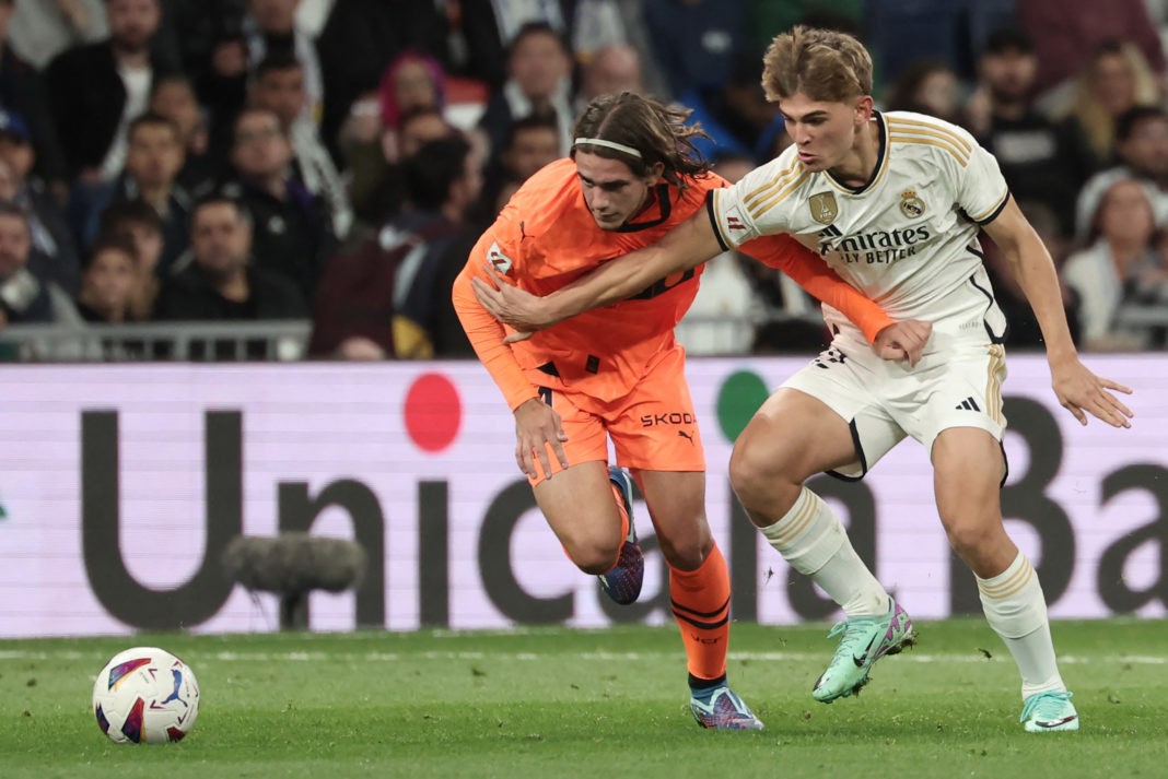 Valencia's Spanish defender #34 Yarek Gasiorowski (L) vies with Real Madrid's Argentinian midfielder #32 Nico Paz during the Spanish league football match between Real Madrid CF and Valencia CF at the Santiago Bernabeu stadium in Madrid on November 11, 2023. (Photo by THOMAS COEX/AFP via Getty Images)