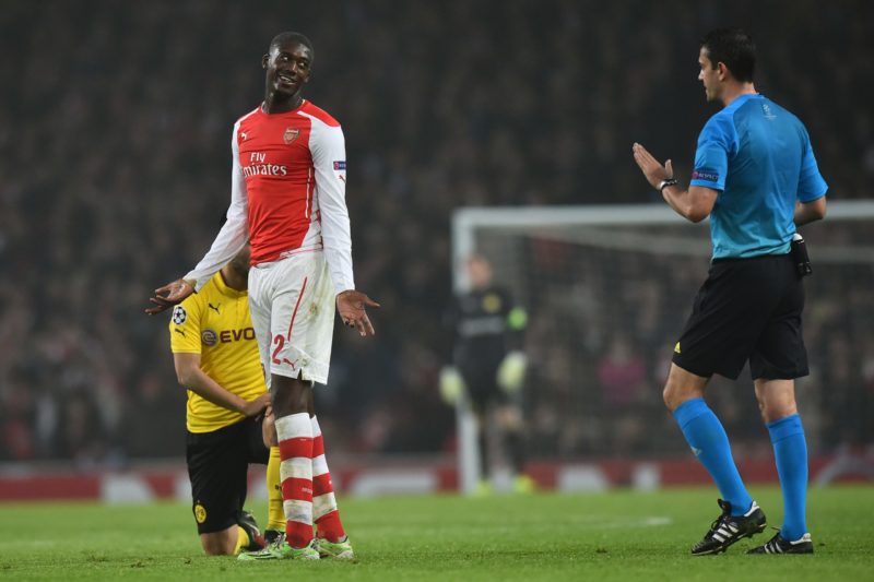 Arsenal's French striker Yaya Sanogo (2L) gestures to Hungarian referee Viktor Kassai (R) after bringing down Dortmund's German midfielder Ilkay Guendogan (L) during the UEFA Champions League Group D football match between Arsenal and Borussia Dortmund at the Emirates Stadium in north London on November 26, 2014. (Photo credit BEN STANSALL/AFP via Getty Images)