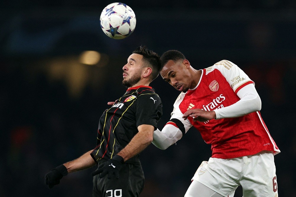 Lens' Przemyslaw Frankowski (L) is challenged by Arsenal's Gabriel Magalhaes during the UEFA Champions League Group B football match between Arsenal and RC Lens at the Arsenal Stadium in north London on November 29, 2023. (Photo by ADRIAN DENNIS/AFP via Getty Images)