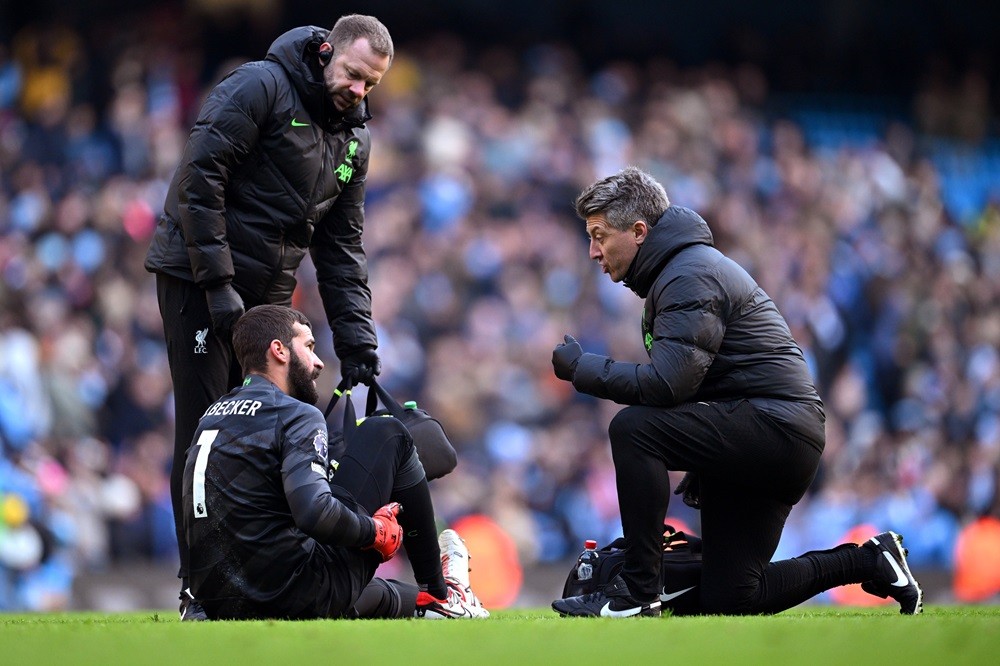 MANCHESTER, ENGLAND: Alisson Becker of Liverpool receives medical treatment following the Premier League match between Manchester City and Liverpool FC at Etihad Stadium on November 25, 2023. (Photo by Michael Regan/Getty Images)