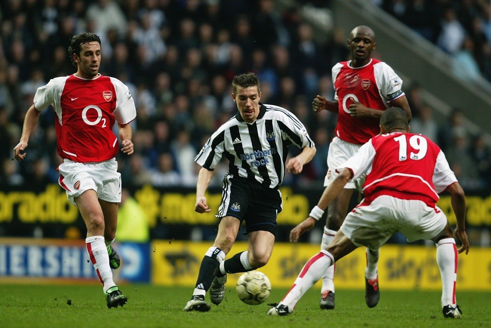 NEWCASTLE:  Darren Ambrose of Newcastle United skips between Edu and Gilberto Silva of Arsenal during the FA Barclaycard Premiership match between Newcastle United and Arsenal at St. James Park on April 11, 2004 in Newcastle, England. (Photo by Ross Kinnaird/Getty Images)