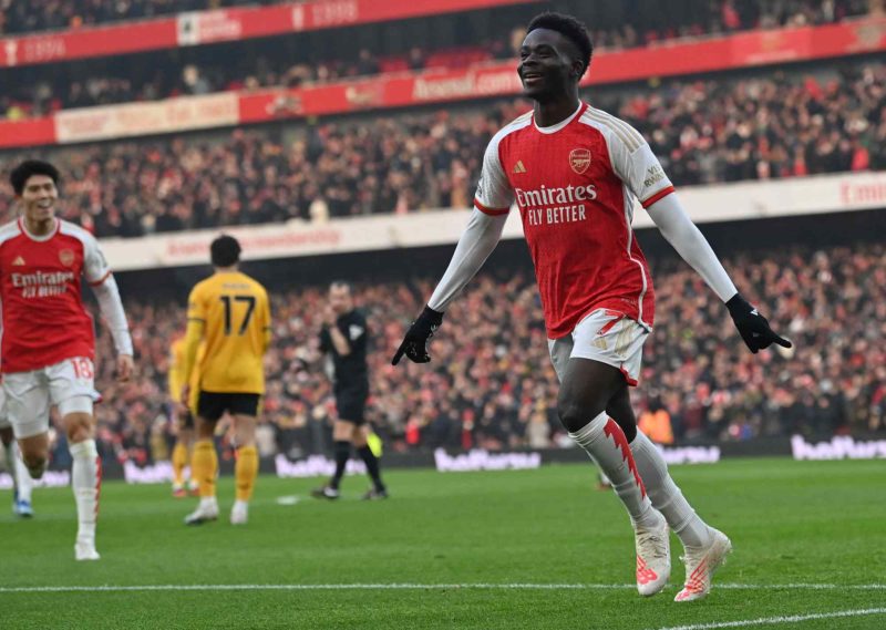 Arsenal's English midfielder #07 Bukayo Saka celebrates scoring the opening goal during the English Premier League football match between Arsenal and Wolverhampton Wanderers at the Emirates Stadium in London on December 2, 2023. (Photo by GLYN KIRK/AFP via Getty Images)