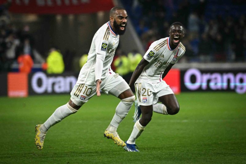 Lyon's French forward #10 Alexandre Lacazette (L) celebrates with Lyon's French defender #20 Sael Kumbedi after scoring a goal during the French L1 football match between Olympique Lyonnais (Lyon) and Toulouse (TFC) at the Groupama Stadium in Lyon, central eastern France, on December 10, 2023. (Photo by OLIVIER CHASSIGNOLE/AFP via Getty Images)