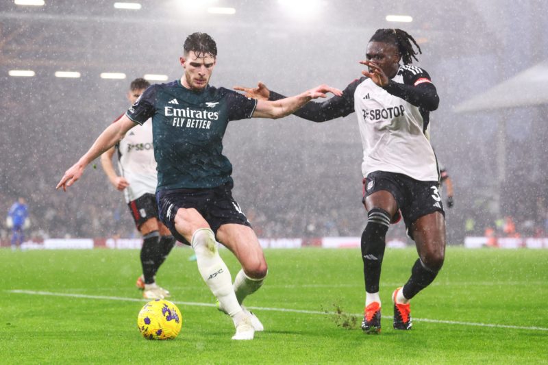 LONDON, ENGLAND - DECEMBER 31: Declan Rice of Arsenal is challenged by Calvin Bassey of Fulham during the Premier League match between Fulham FC and Arsenal FC at Craven Cottage on December 31, 2023 in London, England. (Photo by Clive Rose/Getty Images)