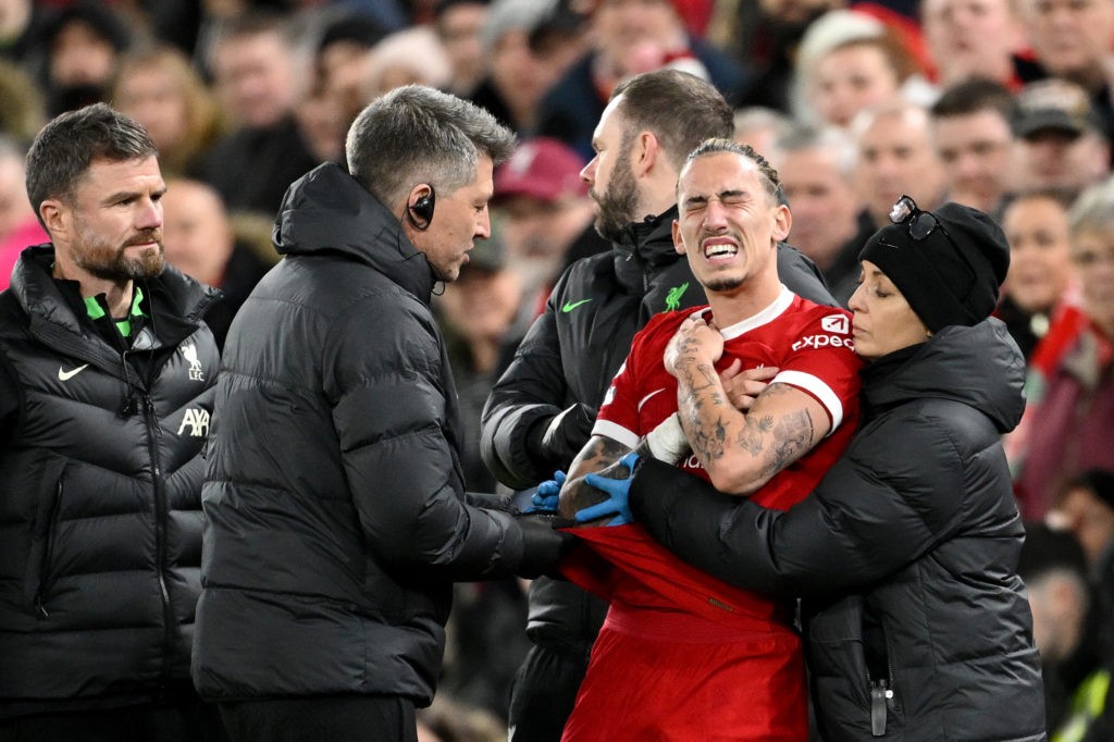 LIVERPOOL, ENGLAND - DECEMBER 23: Kostas Tsimikas of Liverpool receives medical treatment during the Premier League match between Liverpool FC and Arsenal FC at Anfield on December 23, 2023 in Liverpool, England. (Photo by Michael Regan/Getty Images)