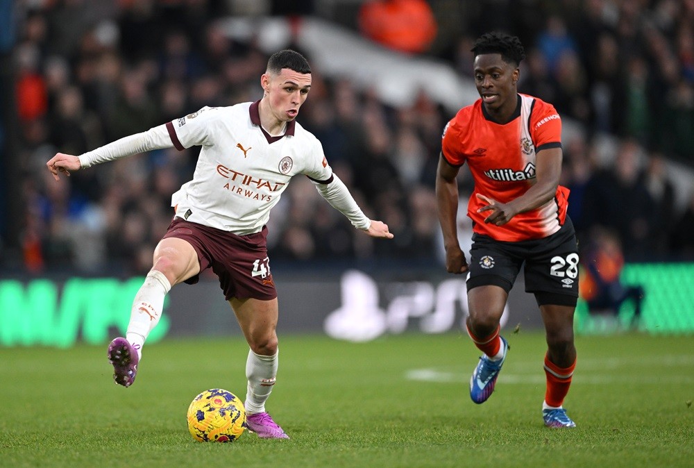 LUTON, ENGLAND: Phil Foden of Manchester City is challenged by Albert Sambi Lokonga of Luton Town during the Premier League match between Luton Town and Manchester City at Kenilworth Road on December 10, 2023. (Photo by Shaun Botterill/Getty Images)