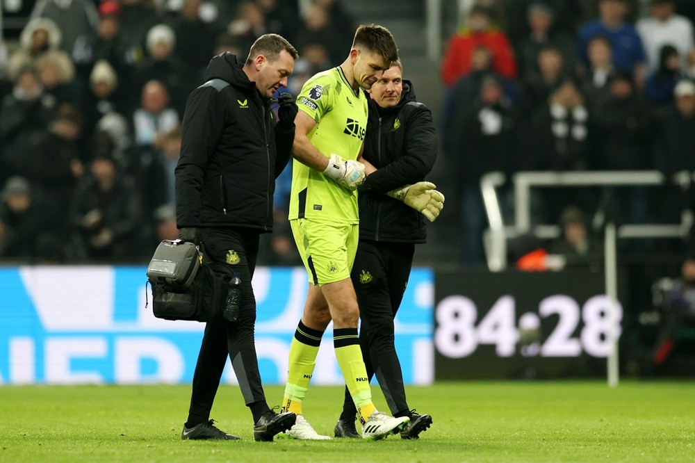 NEWCASTLE UPON TYNE, ENGLAND: Nick Pope of Newcastle United is helped off the pitch after suffering with an injury during the Premier League match between Newcastle United and Manchester United at St. James Park on December 02, 2023. (Photo by Clive Brunskill/Getty Images)