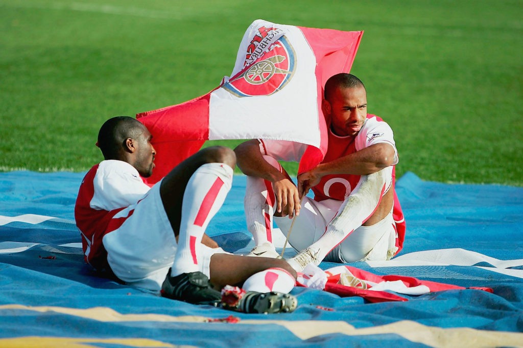 LONDON - MAY 15: Sol Campbell and Thierry Henry of Arsenal take a break during the celebrations as they celebrate winning the Premiership during the FA Barclaycard Premiership match between Arsenal and Leicester City at Highbury on May 15, 2004 in London. (Photo by Clive Mason/Getty Images)