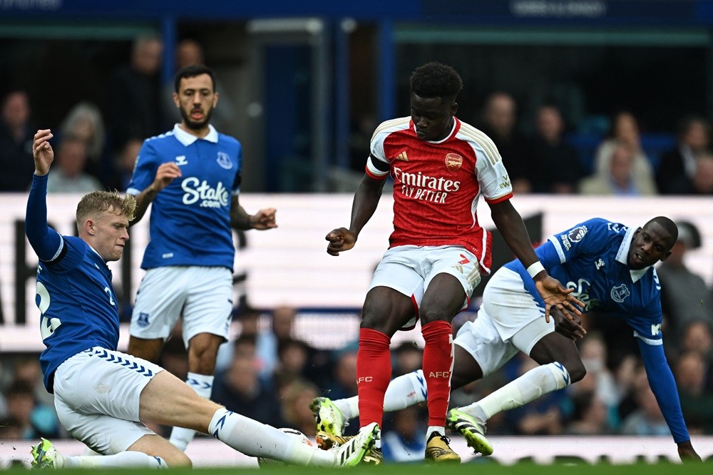 Everton's Jarrad Branthwaite (L) slides in to tackle Arsenal's Bukayo Saka (C) during the English Premier League football match between Everton and Arsenal at Goodison Park in Liverpool, north west England on September 17, 2023. (Photo by PAUL ELLIS/AFP via Getty Images)