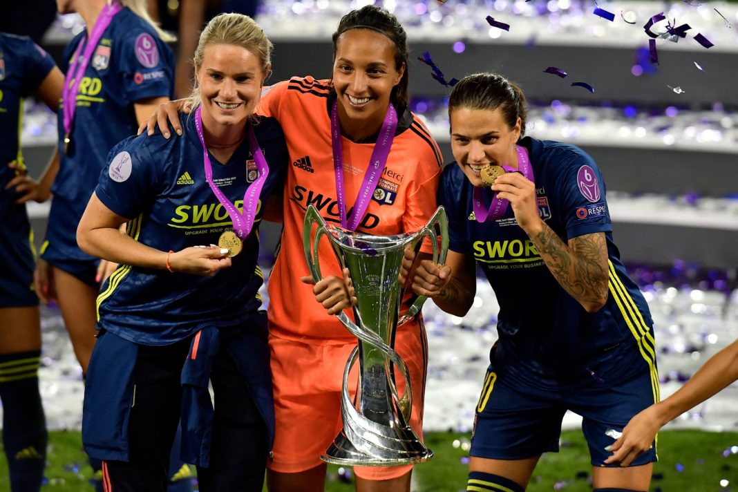 (L to R) Lyon's French midfielder Amandine Henry, Lyon's French goalkeeper Sarah Bouhaddi and Lyon's German midfielder Dzsenifer Marozsan pose with the winner's trophy as they celebrate after winning the UEFA Women's Champions League final football match between VfL Wolfsburg and Lyon at the Anoeta stadium in San Sebastian on August 30, 2020. (Photo by ALVARO BARRIENTOS/POOL/AFP via Getty Images)