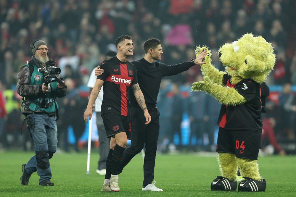 LEVERKUSEN, GERMANY: Granit Xhaka, Xabi Alonso and Brian the Lion celebrate following the team's victory during the Bundesliga match between Bayer 04 Leverkusen and FC Bayern München at BayArena on February 10, 2024. (Photo by Lars Baron/Getty Images)