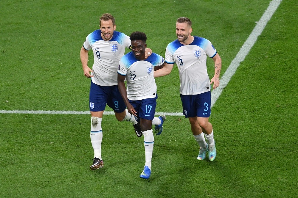 DOHA, QATAR: Bukayo Saka of England celebrates with Harry Kane and Luke Shaw after scoring their team's fourth goal during the FIFA World Cup Qatar 2022 Group B match between England and IR Iran at Khalifa International Stadium on November 21, 2022. (Photo by Justin Setterfield/Getty Images)