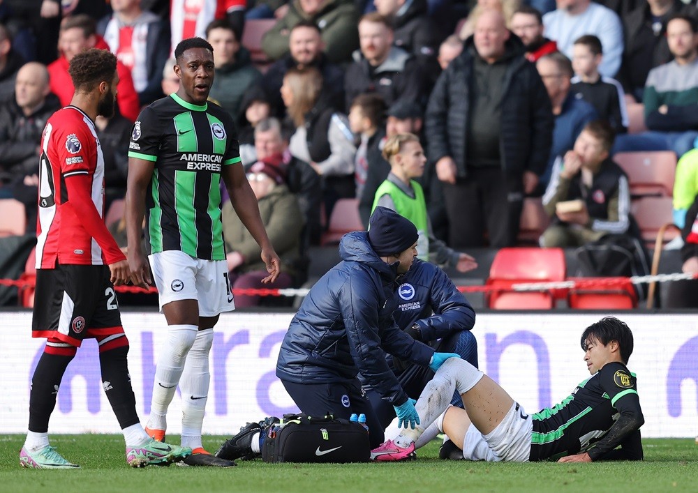 SHEFFIELD, ENGLAND: Kaoru Mitoma of Brighton & Hove Albion receives medical treatment after being fouled by Mason Holgate of Sheffield United (not pictured), which leads to a red card during the Premier League match between Sheffield United and Brighton & Hove Albion at Bramall Lane on February 18, 2024. (Photo by Matt McNulty/Getty Images)
