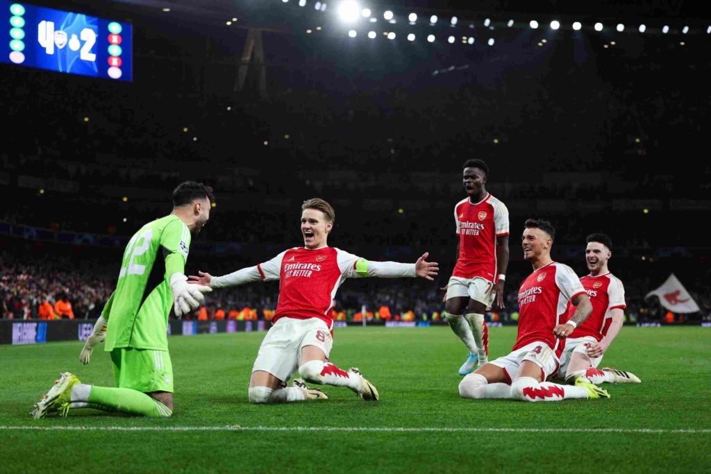 (From L) Arsenal's Spanish goalkeeper #22 David Raya, Arsenal's Norwegian midfielder #08 Martin Odegaard, Arsenal's English midfielder #07 Bukayo Saka, Arsenal's English defender #04 Ben White and Arsenal's English midfielder #41 Declan Rice celebrate after winning the penalty shoot-out session of the UEFA Champions League last 16 second leg football match between Arsenal and Porto FC at the Arsenal Stadium in north London, on March 12, 2024. Arsenal edged out Porto on penalties to reach the Champions League quarter-finals for the first time since 2010. (Photo by ADRIAN DENNIS/AFP via Getty Images)