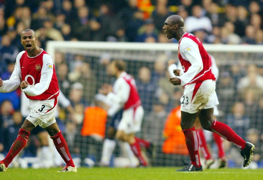 LONDON, UNITED KINGDOM: Arsenal's Ashley Cole (L) and Sol Campbell (R) react to Arsenal's equaliser against Tottenham Hotspur during the Premiership match at White Hart Lane in London 15 December 2002. (Photo via ADRIAN DENNIS/AFP via Getty Images)