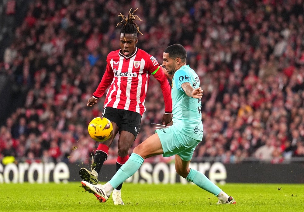 BILBAO, SPAIN: Nico Williams of Athletic Club passes the ball whilst under pressure from Omar Mascarell of RCD Mallorca during the LaLiga EA Sports match between Athletic Bilbao and RCD Mallorca at Estadio de San Mames on February 02, 2024. (Photo by Juan Manuel Serrano Arce/Getty Images)