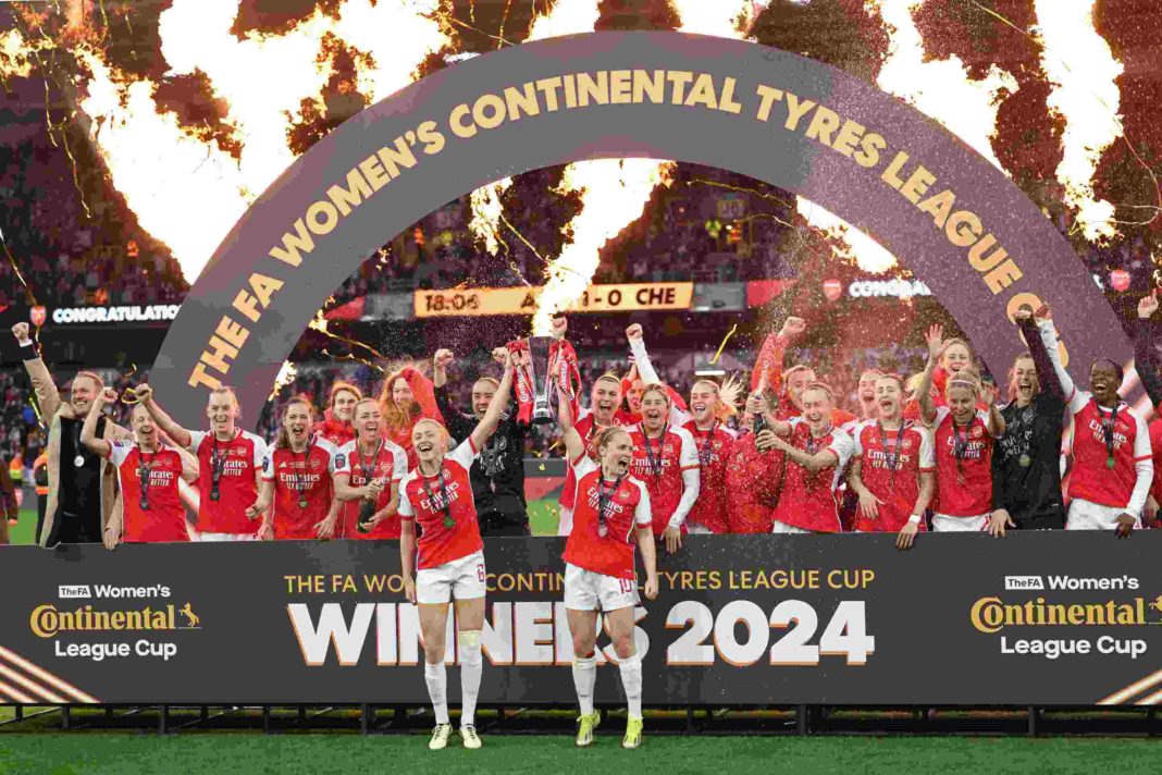 Arsenal's English defender #06 Leah Williamson (centre left) and Arsenal's Scottish midfielder #10 Kim Little (centre right) hold the trophy as Arsenal's players celebrate their win after the English Women's League Cup final football match between Arsenal and Chelsea at Molineux in Wolverhampton, central England on March 31, 2024. Arsenal won the game 1-0 after extra time. (Photo by Adrian DENNIS / AFP) (Photo by ADRIAN DENNIS/AFP via Getty Images)