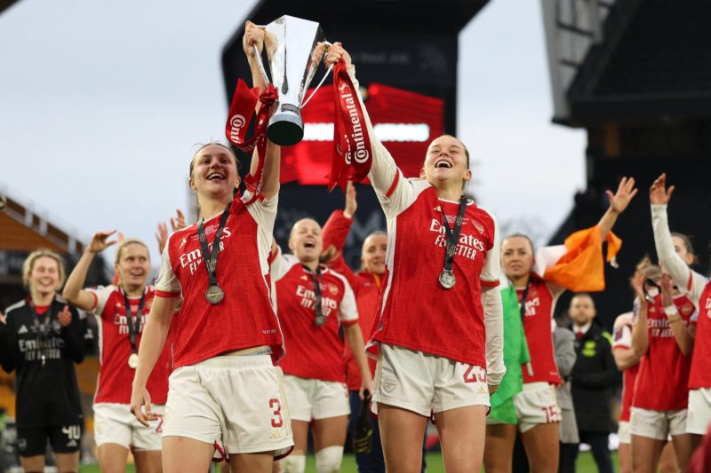 Arsenal's English defender #03 Lotte Wubben-Moy (centre left) and Arsenal's English striker #23 Alessia Russo (centre right) hold the trophy as Arsenal's players celebrate their win after the English Women's League Cup final football match between Arsenal and Chelsea at Molineux in Wolverhampton, central England on March 31, 2024. Arsenal won the game 1-0 after extra time. (Photo by Adrian DENNIS / AFP) (Photo by ADRIAN DENNIS/AFP via Getty Images)